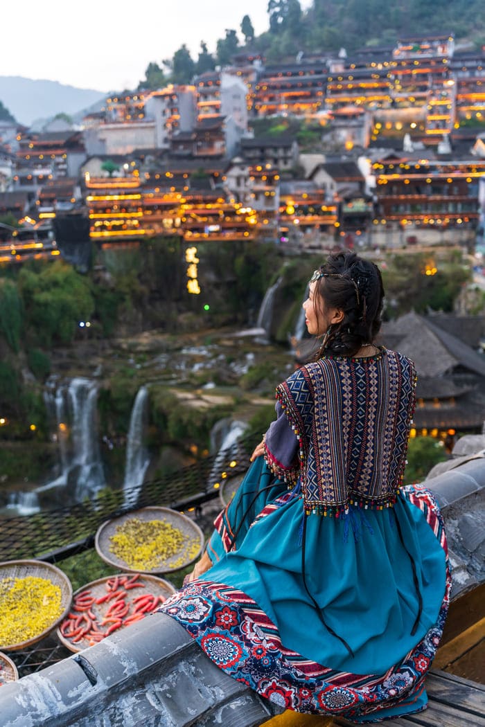Mujer de espaldas viendo hacia la ciudad de Lijiang, China